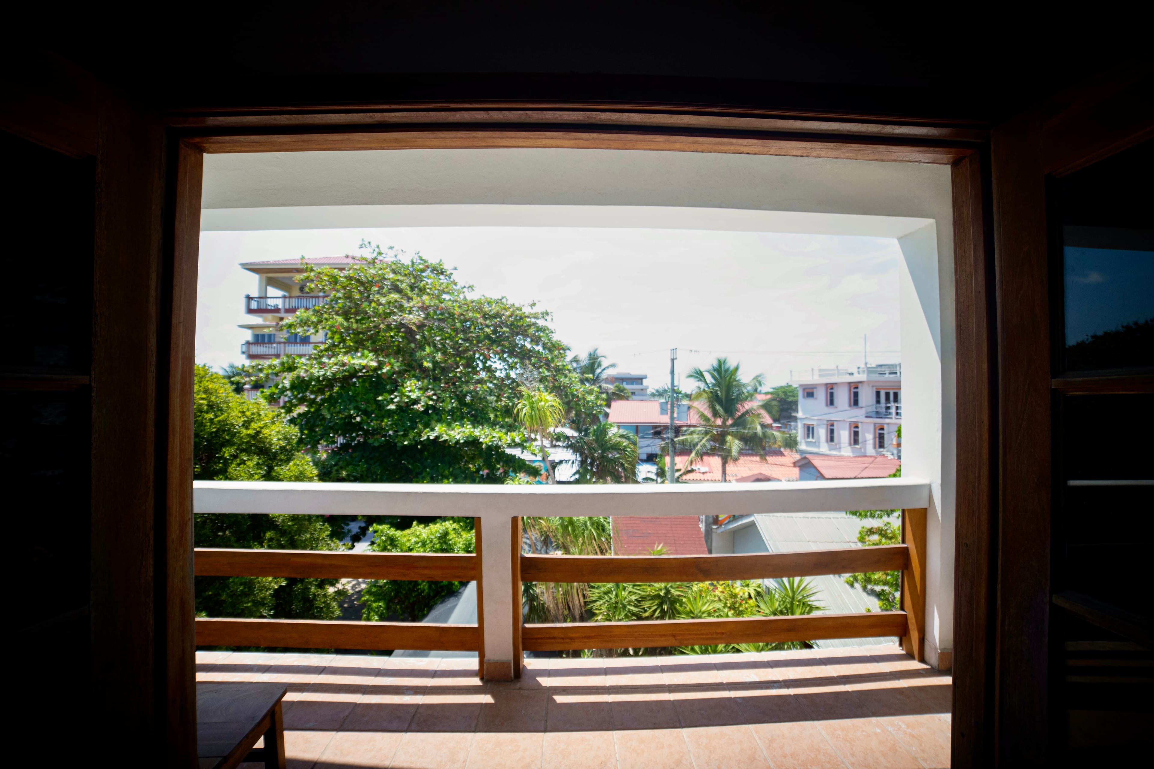 A beautiful resort with white archways and wooden railings surrounds a sparkling turquoise pool, with palm trees adding to the tropical ambiance.