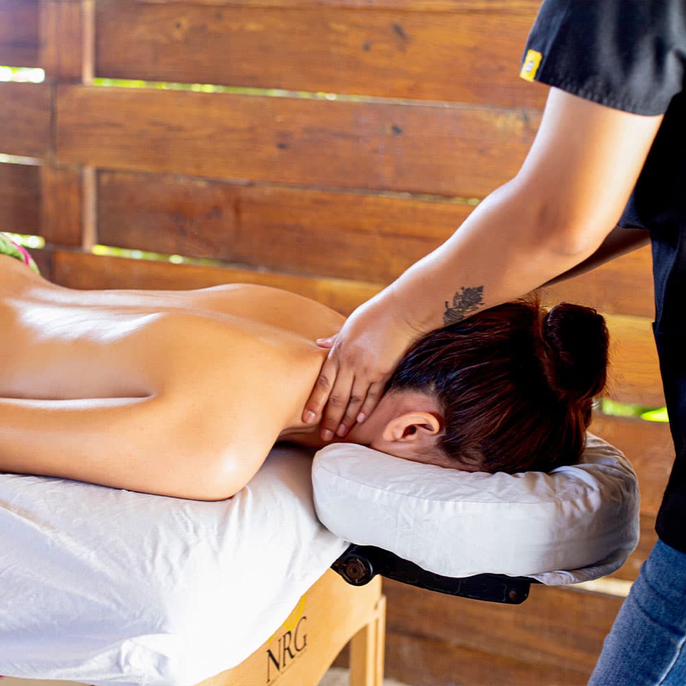 A person receiving a neck massage on a massage table.
